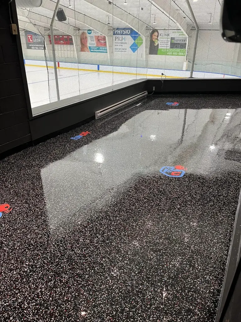 Indoor commercial epoxy flooring with a glossy finish, featuring non-slip surface and colorful markings, designed for durability and safety in high-traffic areas.