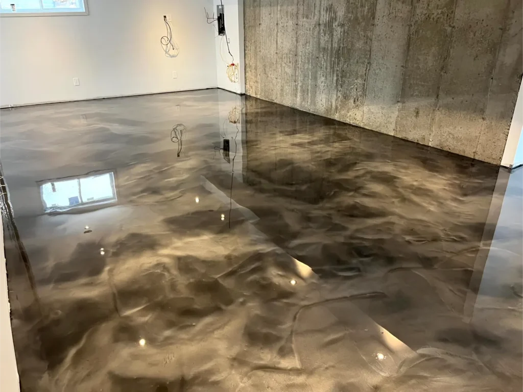 Epoxy flooring installation showcasing a polished, reflective surface in a residential setting, highlighting durability and aesthetic appeal, aligned with Bétonik Inc.'s concrete finishing services.