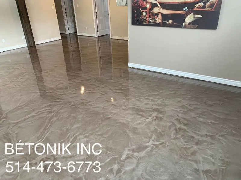 Epoxy floor with a glossy finish in a residential setting, featuring a Bétonik Inc. logo and contact information, illustrating professional epoxy flooring maintenance.