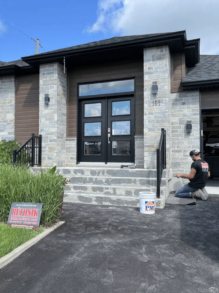 Concrete steps being repaired by a contractor in front of a residential home, with a Bétonik sign prominently displayed, emphasizing professional concrete repair services.