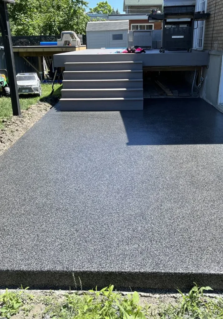 Finition de béton en surface lisse et antidérapante, avec escalier en bois, pour aménagement extérieur, illustrant les services de Bétonik.