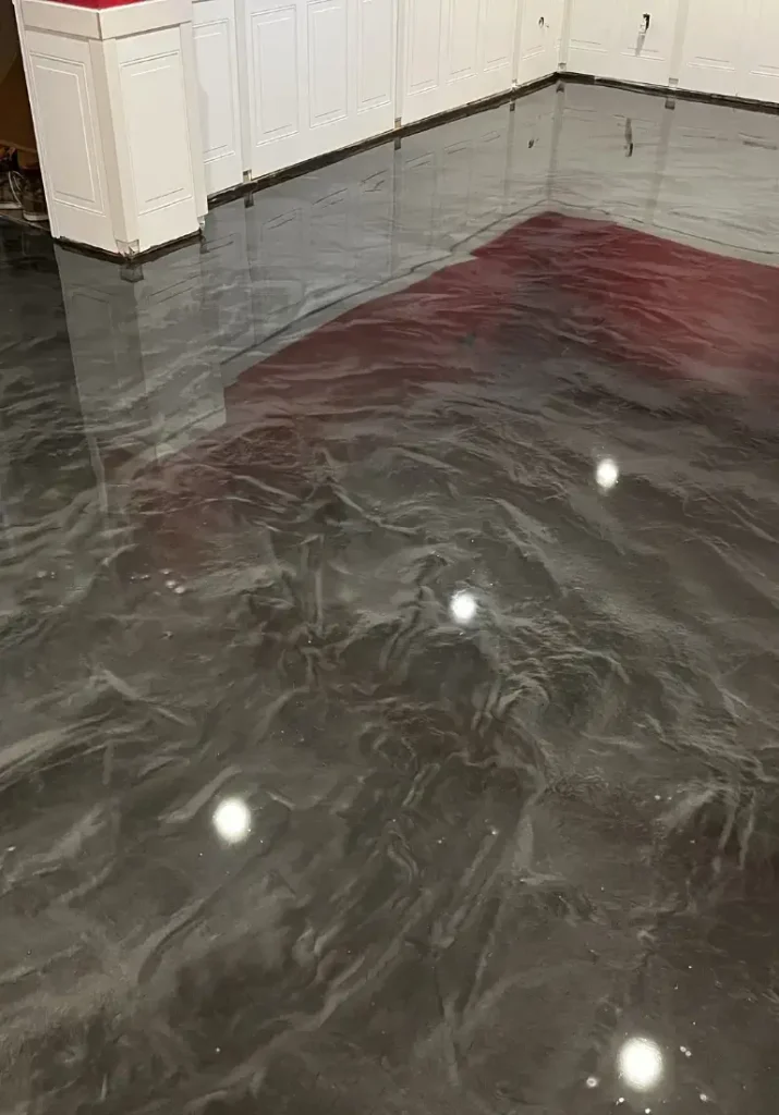 Plancher en époxy métallisé noir avec des reflets brillants, conçu pour un espace commercial, mettant en valeur une surface durable et esthétique.