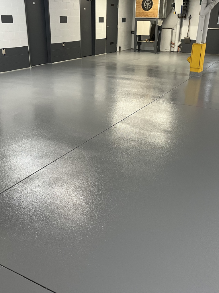 Plancher époxy gris d'un stationnement intérieur de condo avec lignes de cases contrastantes