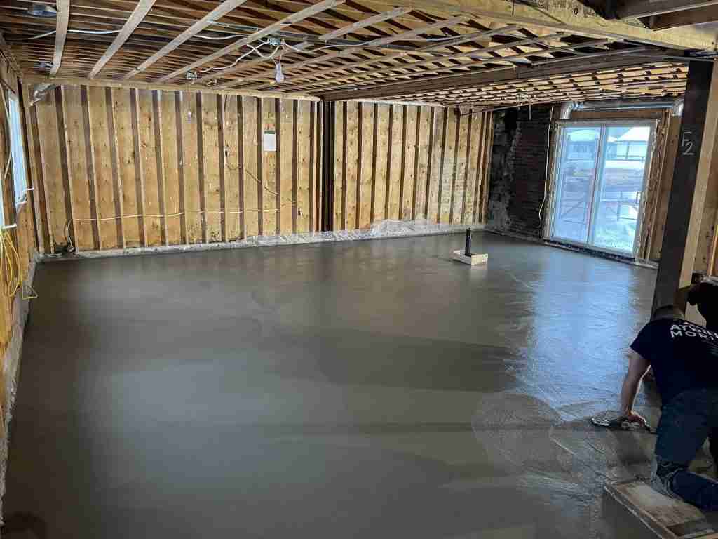 Coulée et lissage d'une dalle de béton dans un sous-sol de Rivière-des-Prairies
