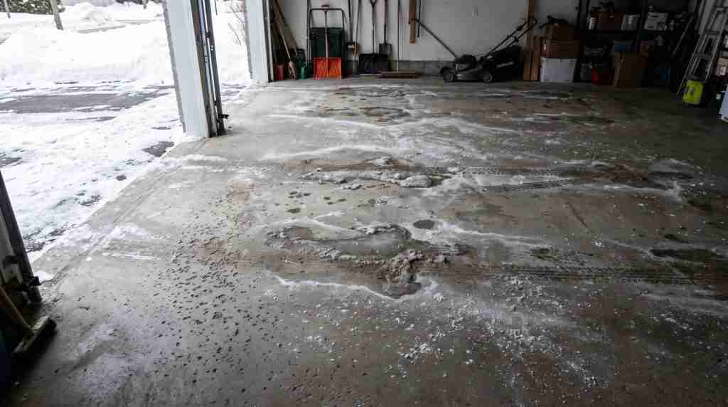 Dalle de garage en béton nu tachée par le sel de déglaçage en hiver
