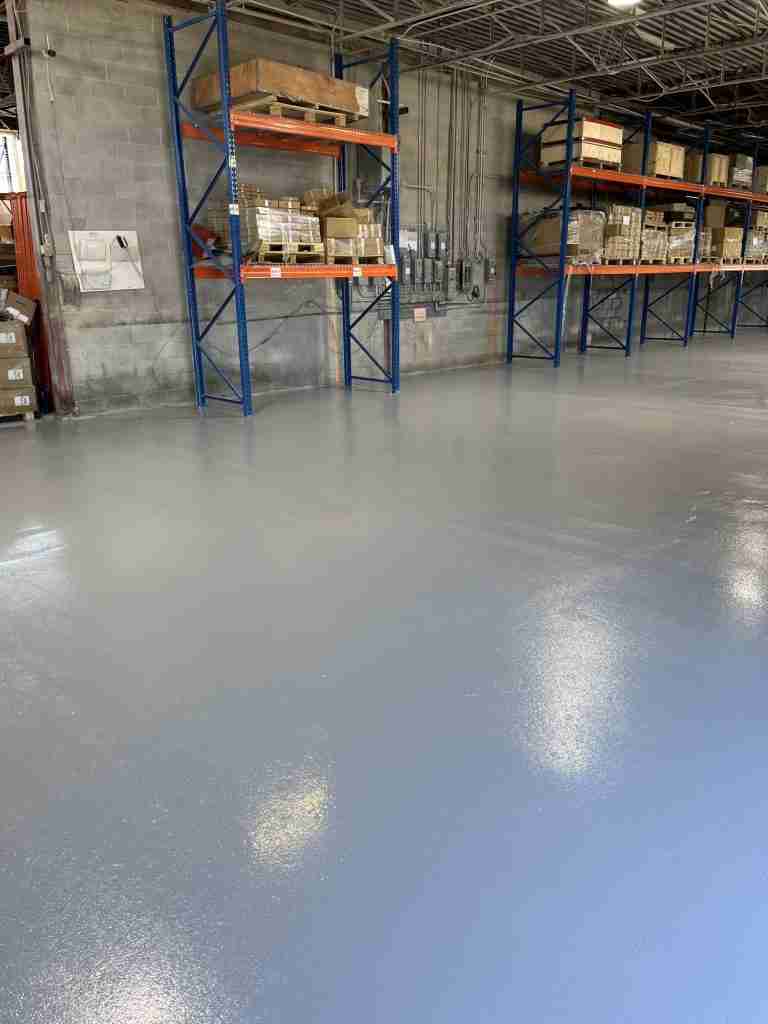 Allée d'entrepôt à Anjou avec plancher époxy gris lustré