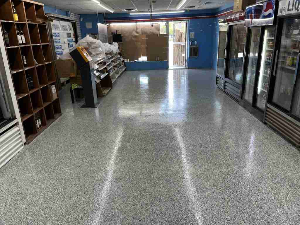 Light grey flake epoxy floor in a convenience store, installed by B&eacute;tonik
